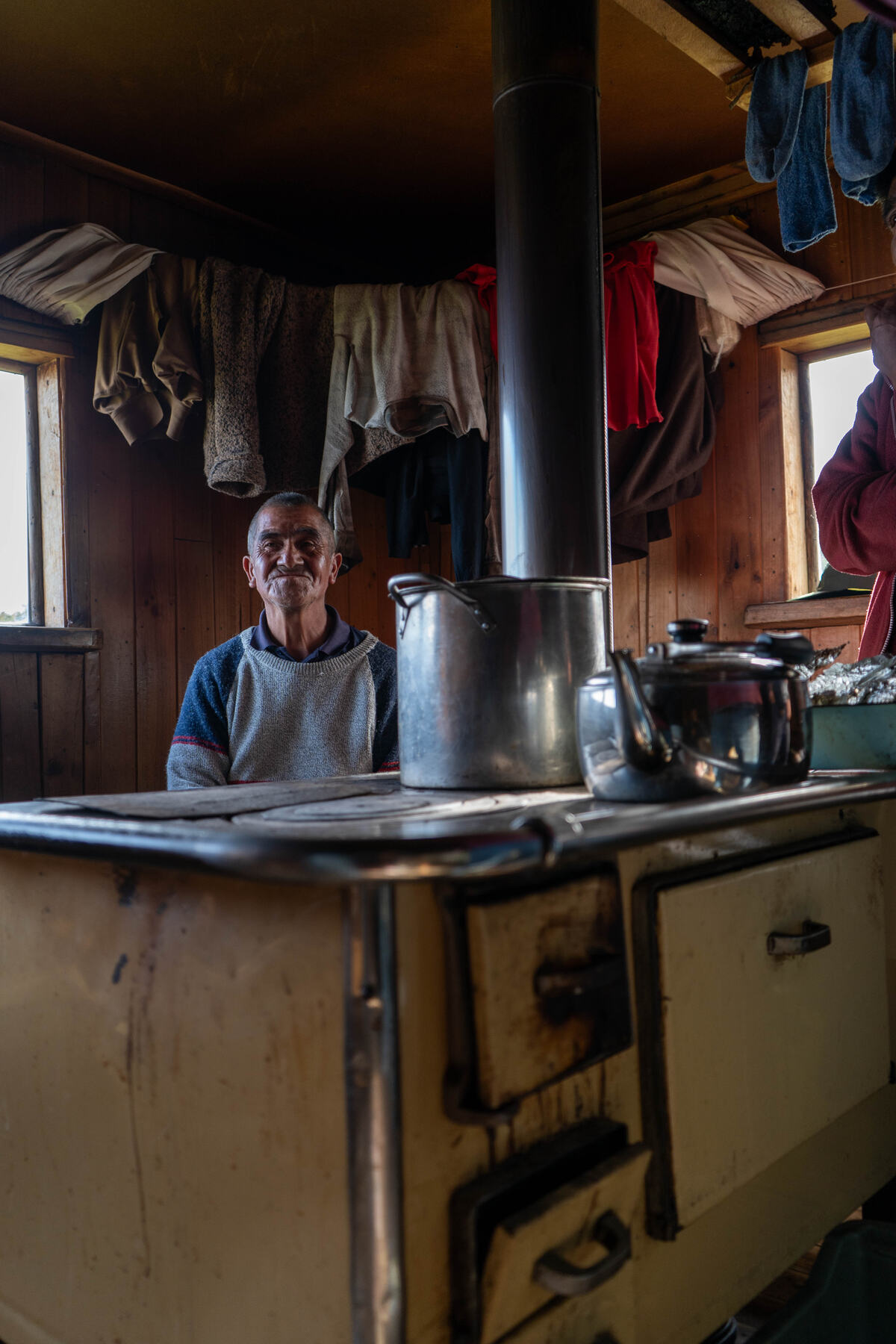 Cocina a leña dentro de una casa chilota con luz de ventana